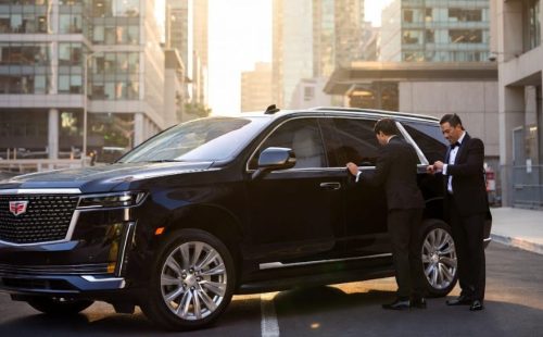 Black Cadillac Escalade SUV with professional chauffeur — bold groom's wedding ride, seats 6, urban backdrop, Wedding Limo Toronto.